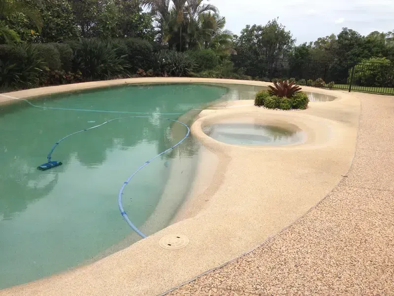 Curved Backyard Swimming Pool With Shallow SPA — Mad Pool Interiors and Renovations in Baringa, QLD