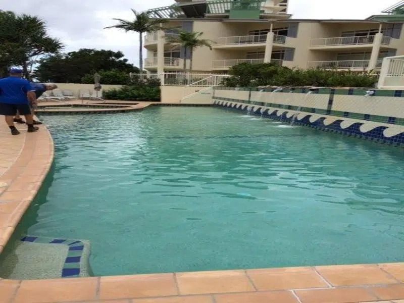 Outdoor Swimming Pool With Turquoise Water Beside a Hotel Courtyard — Mad Pool Interiors and Renovations in Baringa, QLD