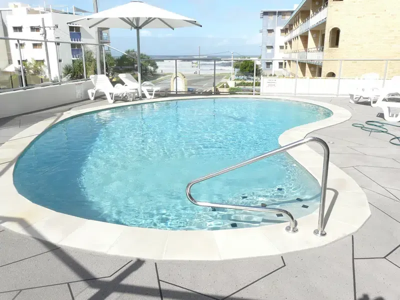 Pool With Clear Blue Water and a Beach View — Mad Pool Interiors and Renovations in Baringa, QLD
