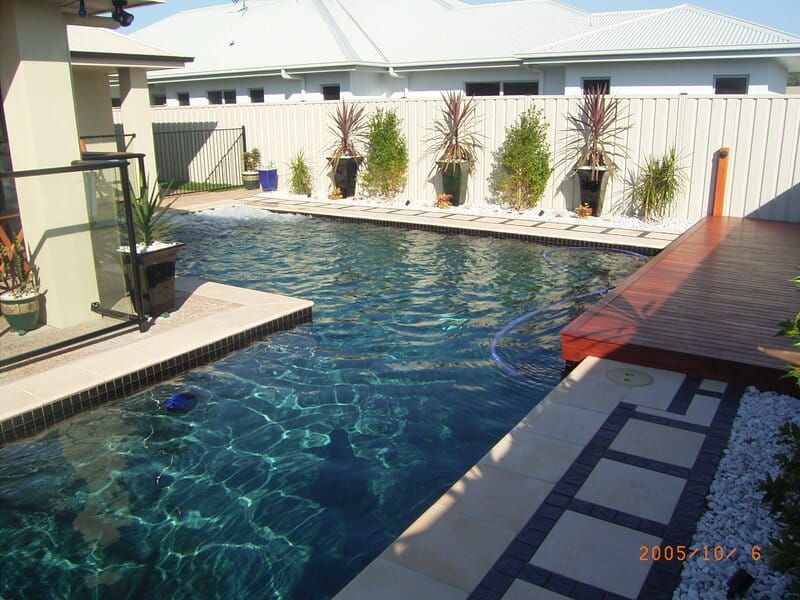 Swimming Pool With Dark Water and Beige and Dark Tile Surrounds — Mad Pool Interiors and Renovations in Baringa, QLD