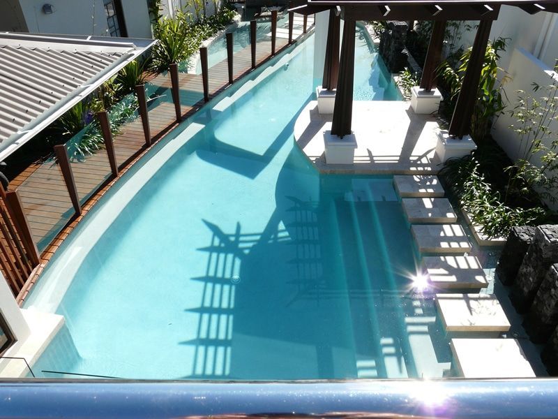 Long, Narrow Outdoor Swimming Pool With Wooden Pergola and Stone Walkway — Mad Pool Interiors and Renovations in Baringa, QLD