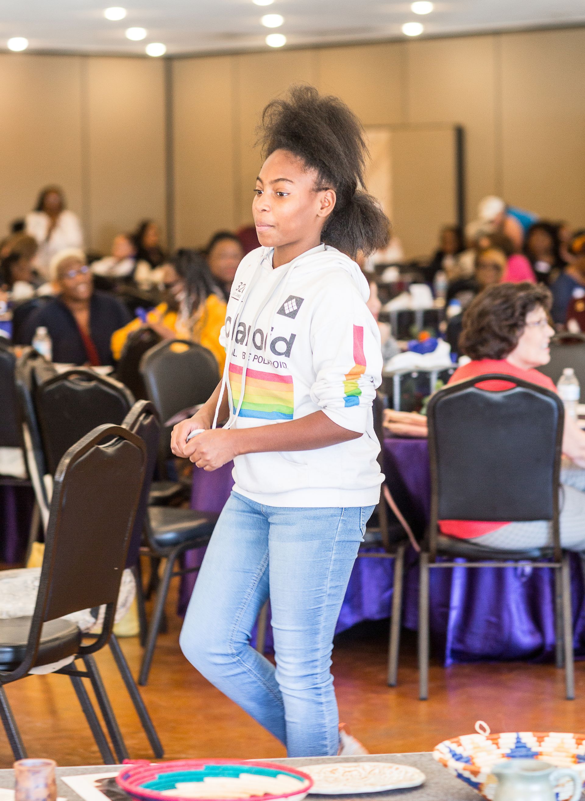 A woman is standing in front of a table with a plate of food on it.