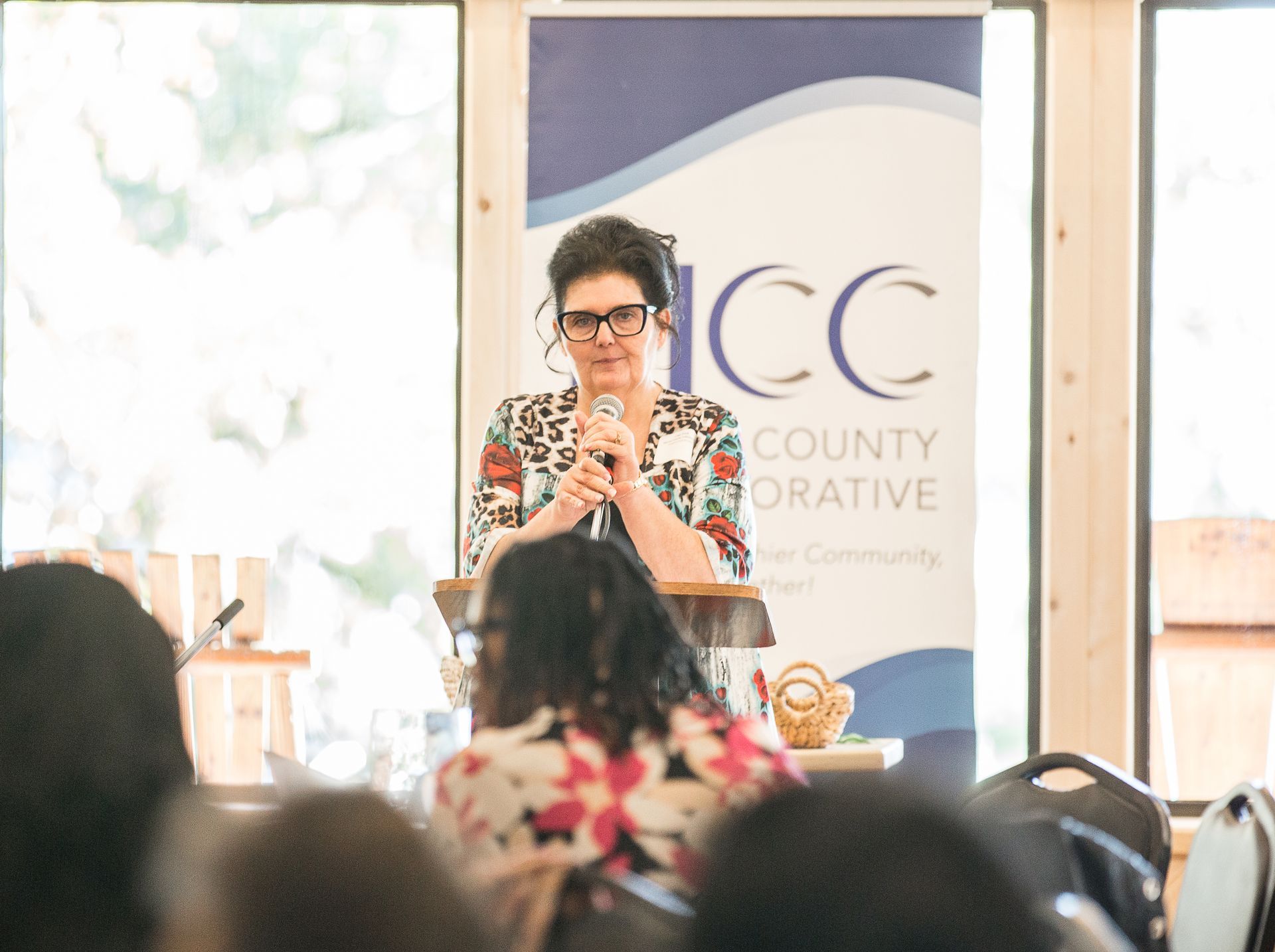 A woman is standing at a podium giving a presentation to a group of people.