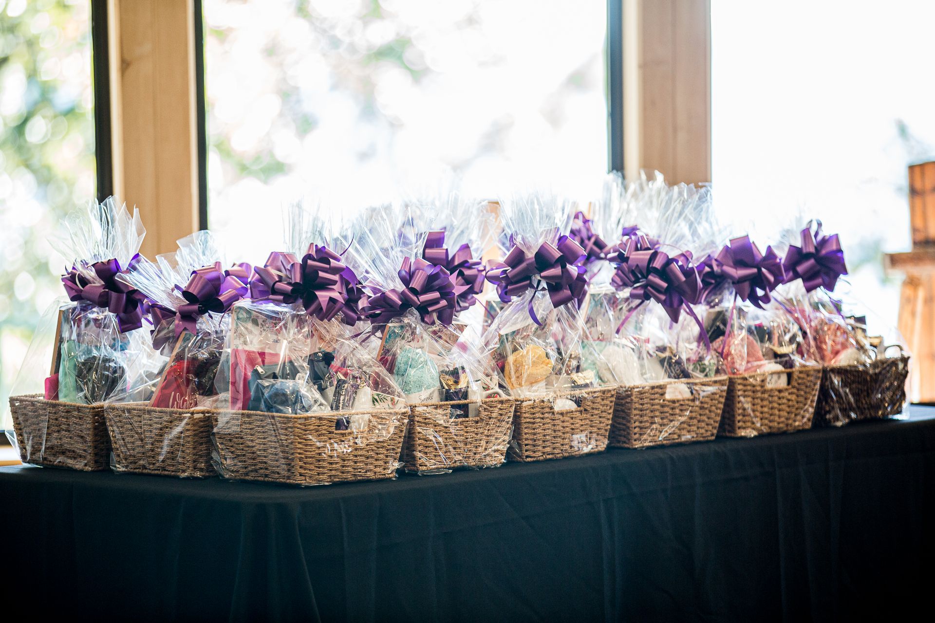 A row of baskets filled with purple bows are sitting on a table.