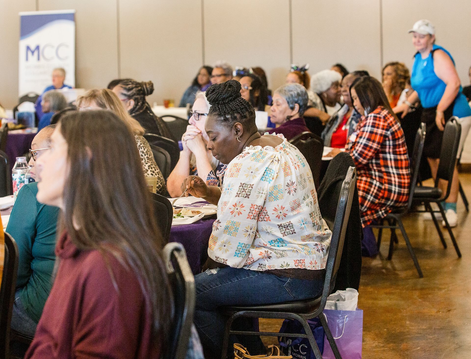 A group of people are sitting at tables in a room.