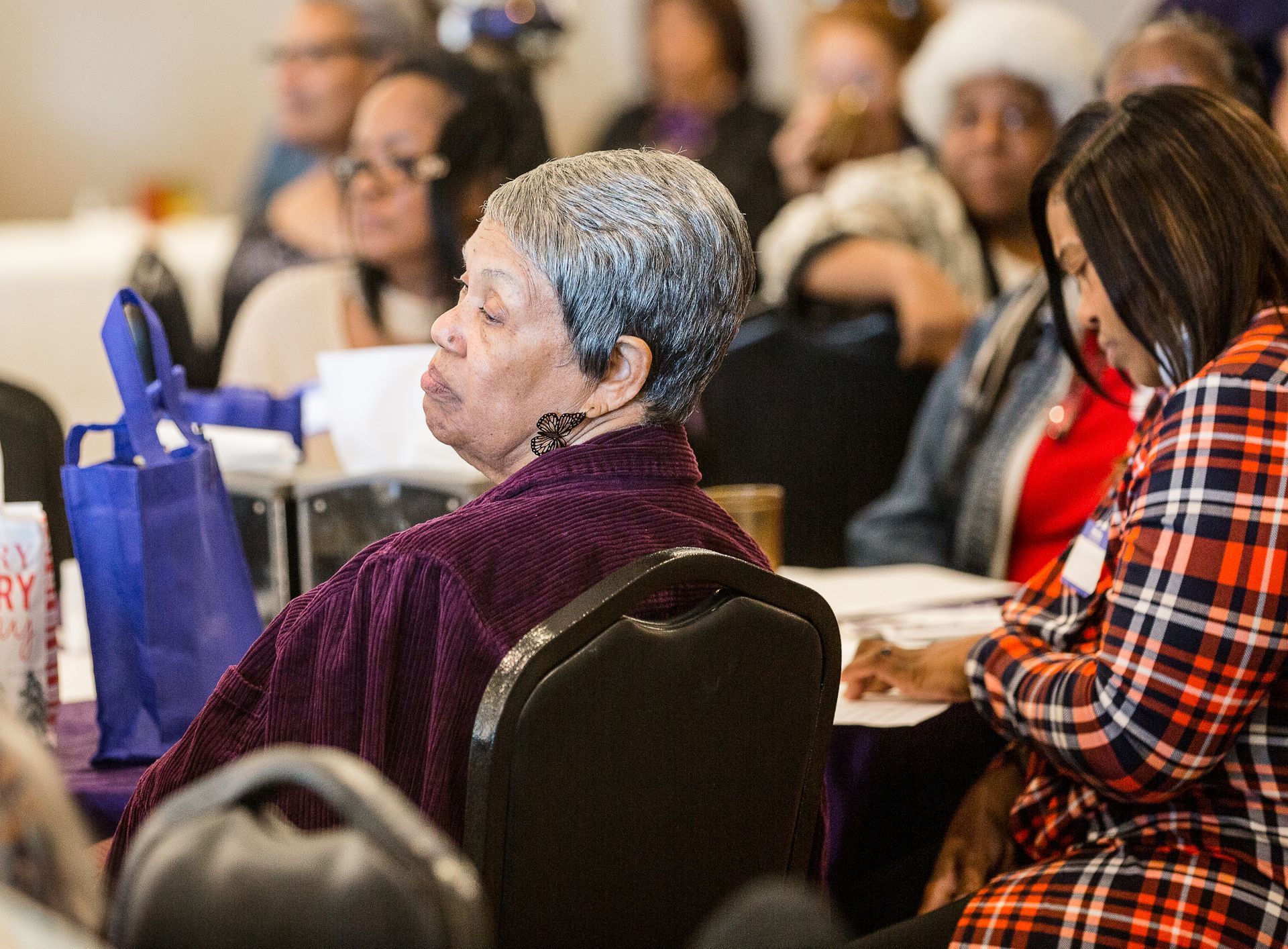 A group of people are sitting in chairs at a conference.