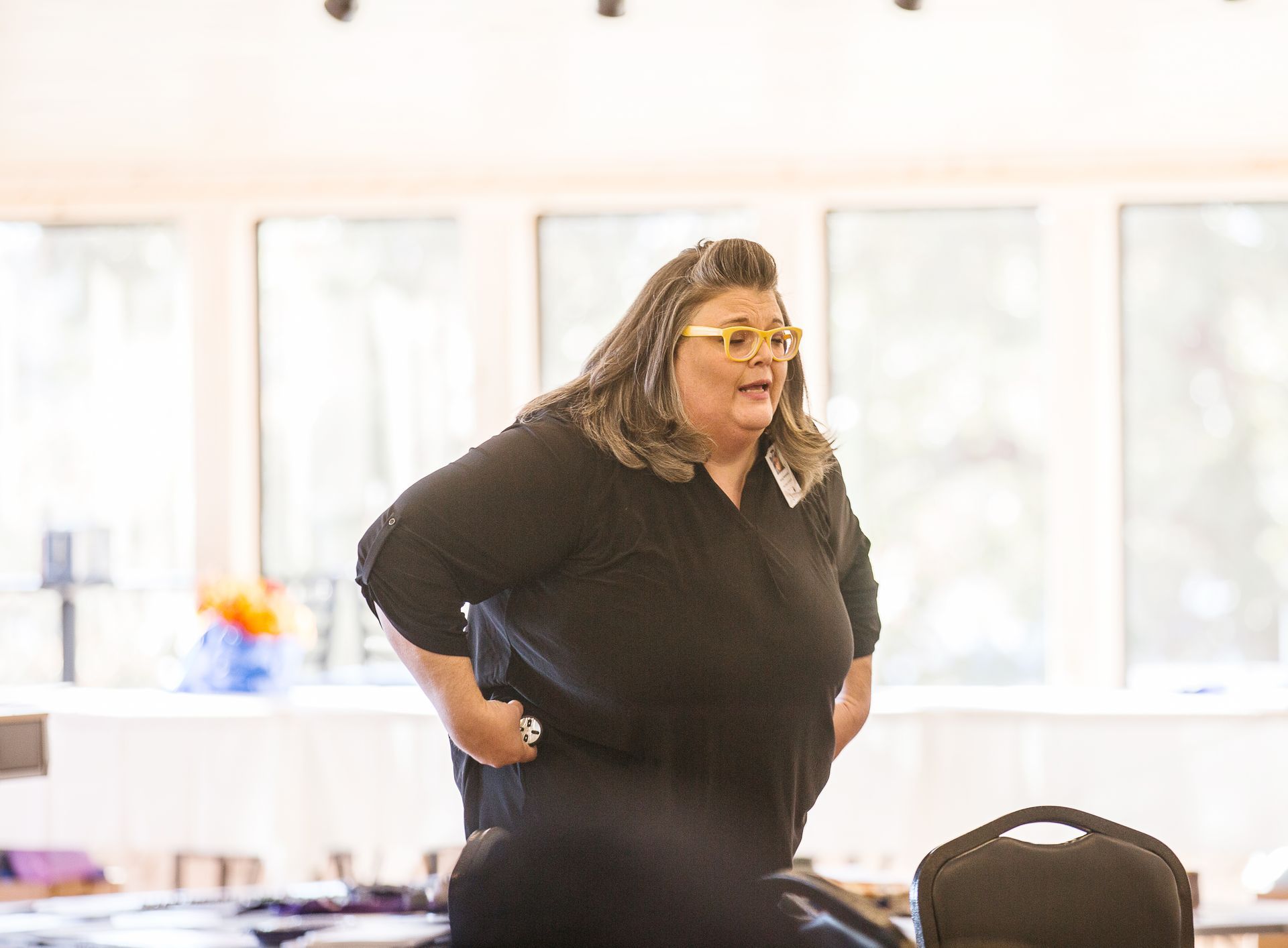 A woman is standing in a room with her hands on her hips.