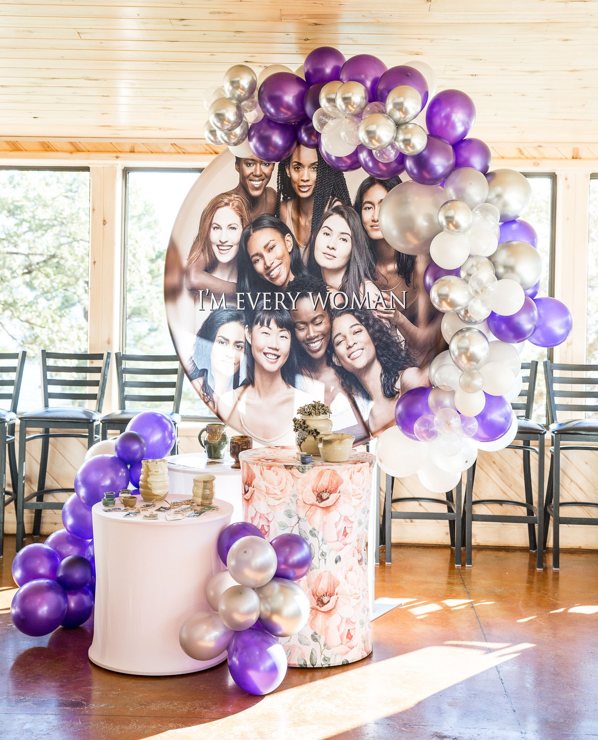 A picture of a group of women is surrounded by purple and silver balloons.