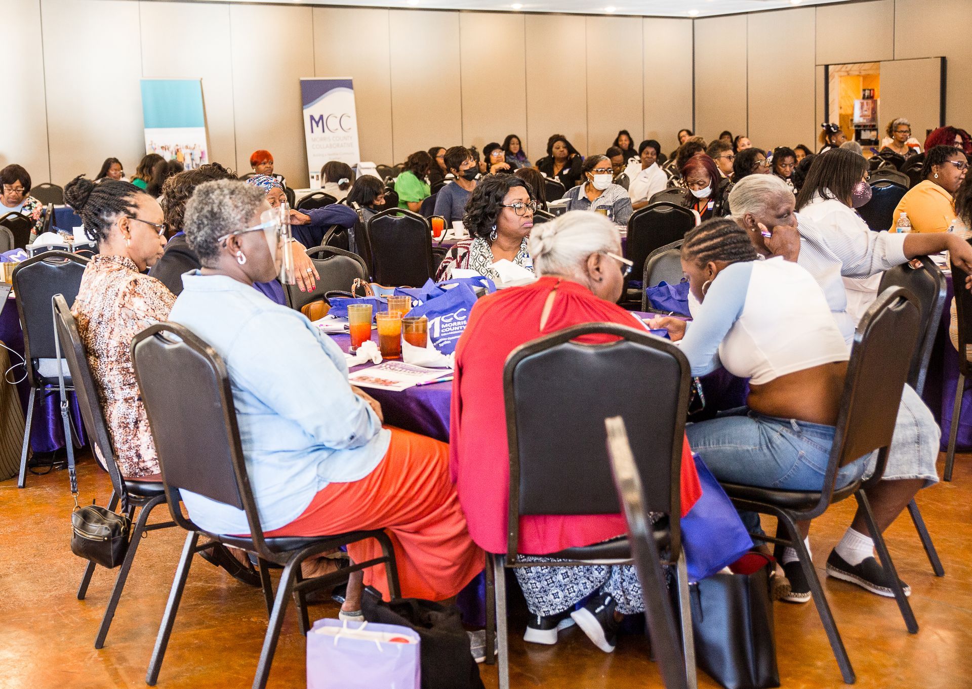 A group of people are sitting at tables in a room.