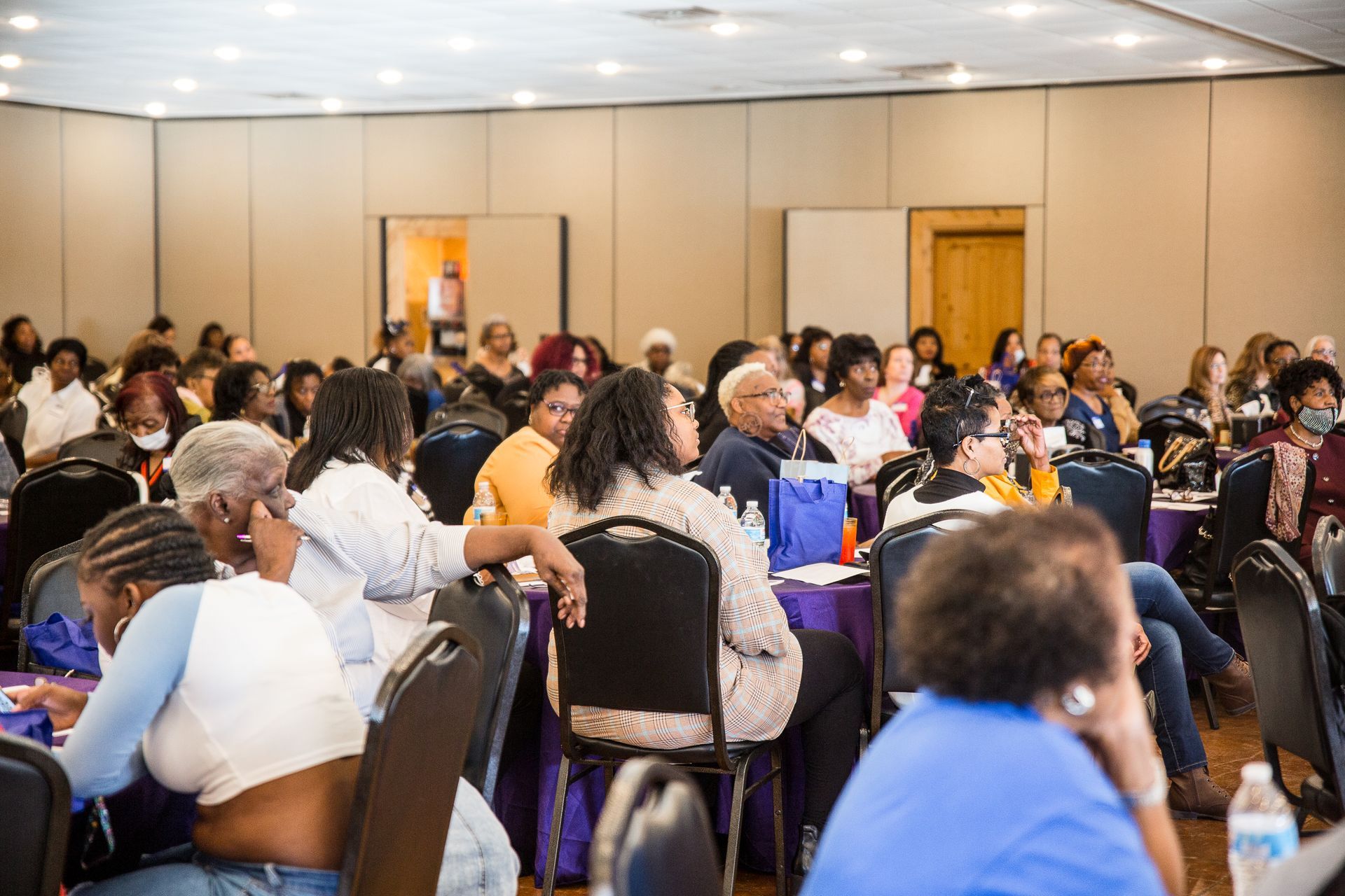 A large group of people are sitting in a conference room.