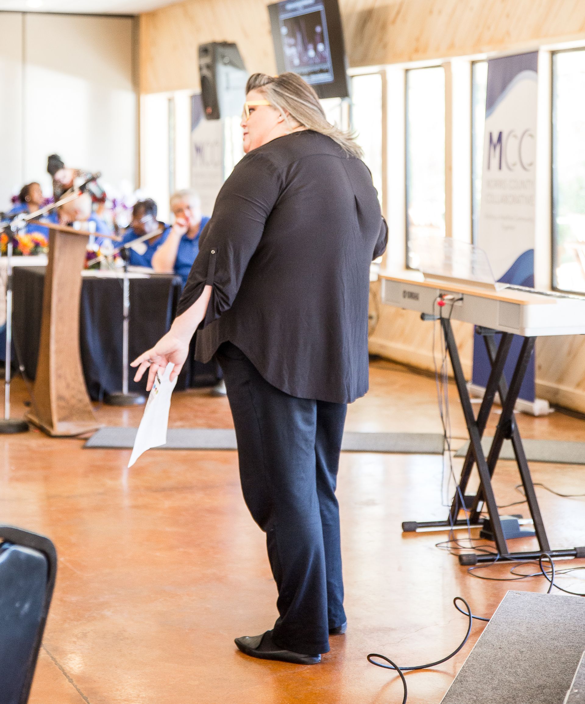 A woman is standing in front of a mcc sign