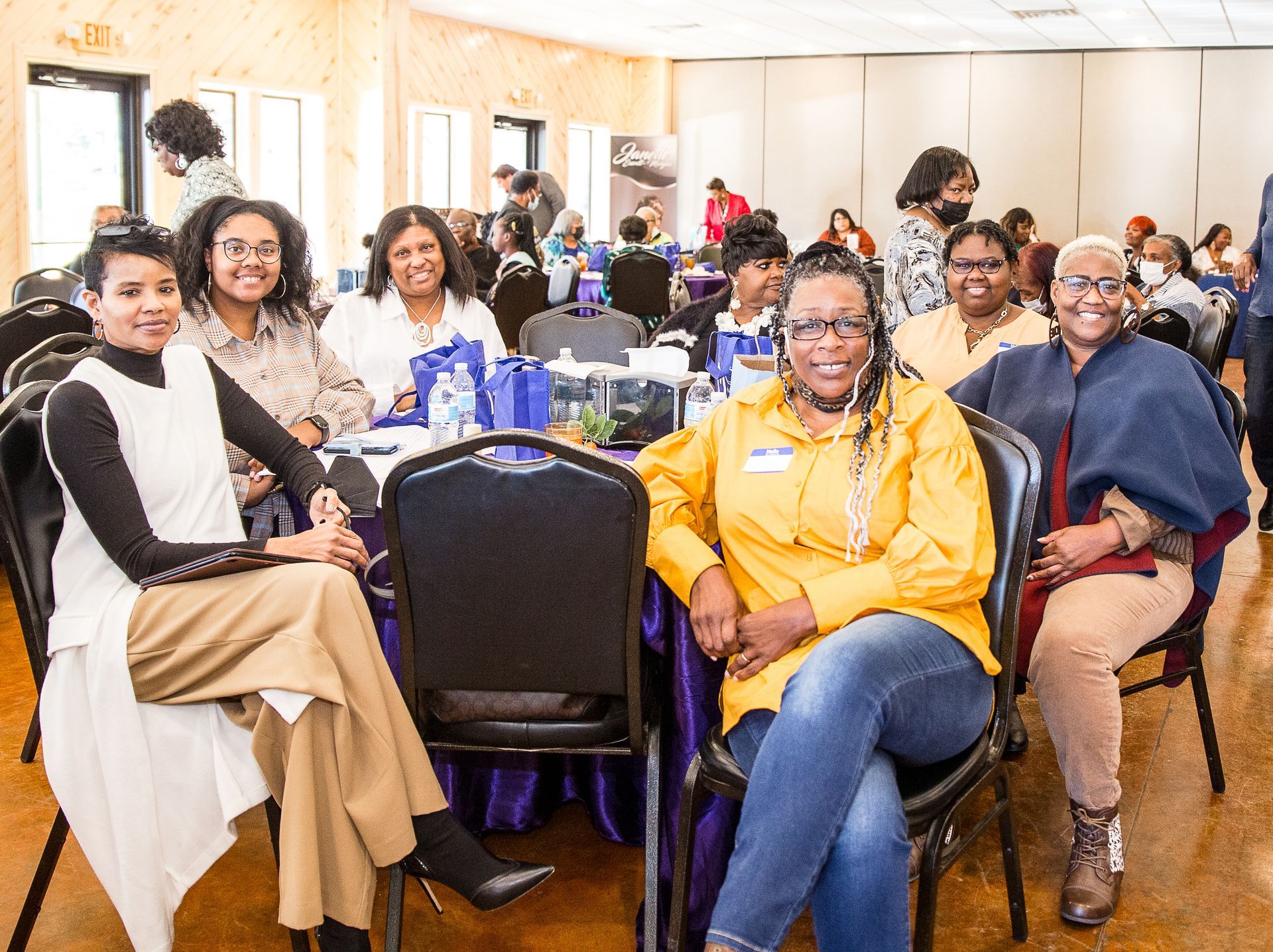 A group of women are sitting at a table in a room.