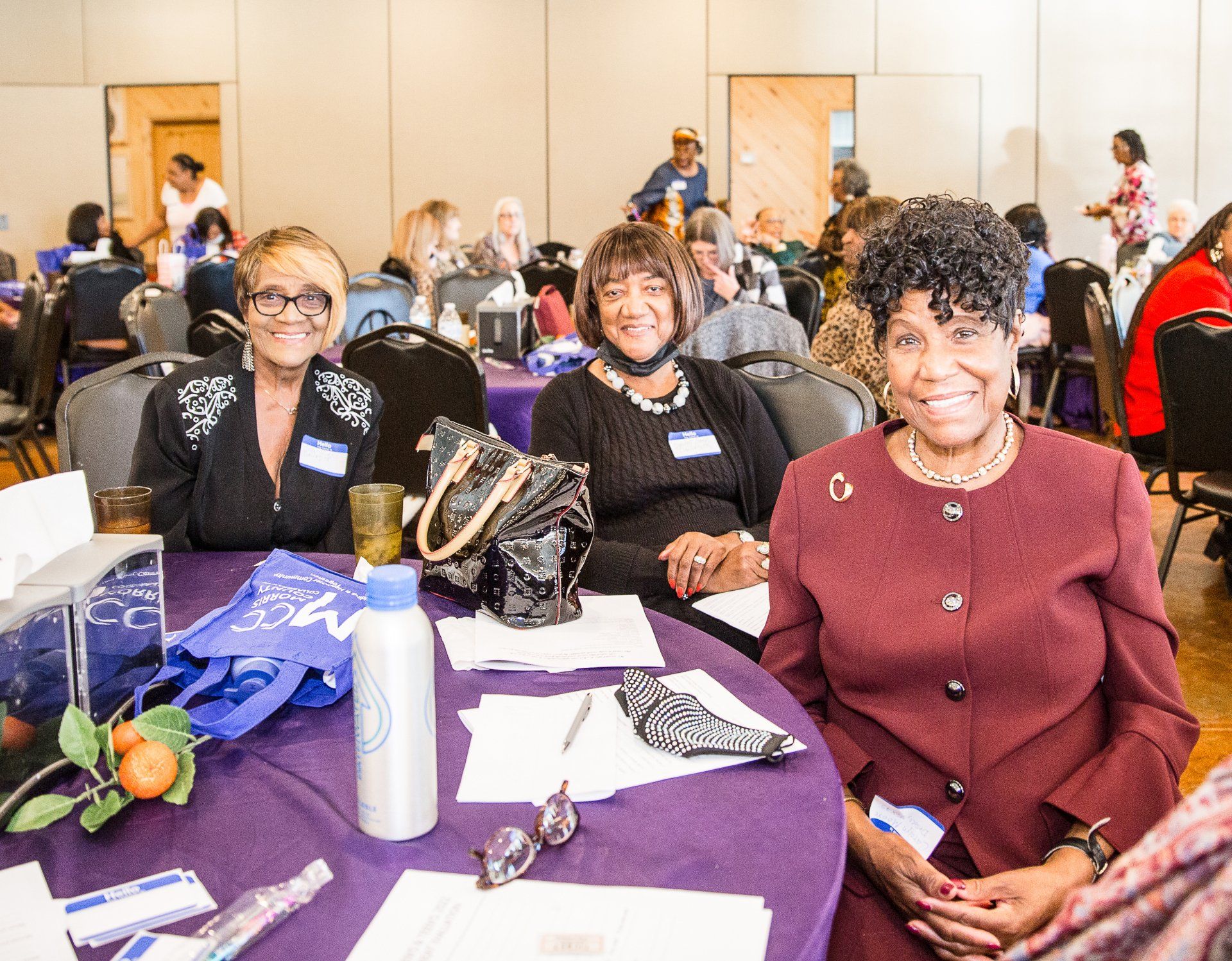 Three women are sitting at a table in a room.