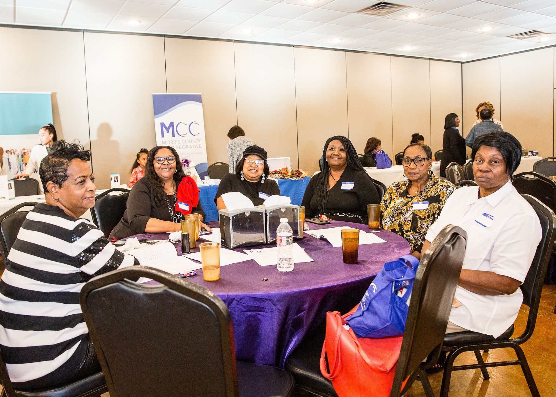 A group of women are sitting at a table in a room.