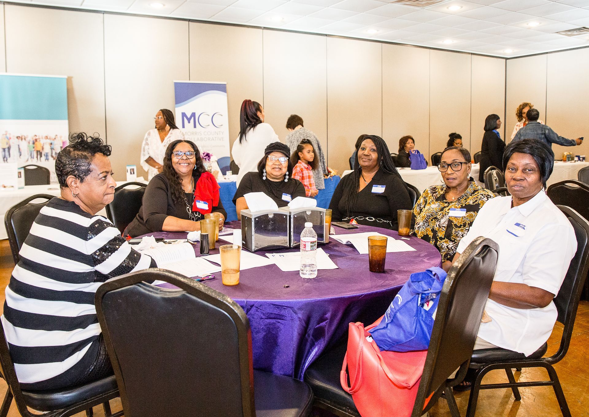 A group of people are sitting at tables in a room.
