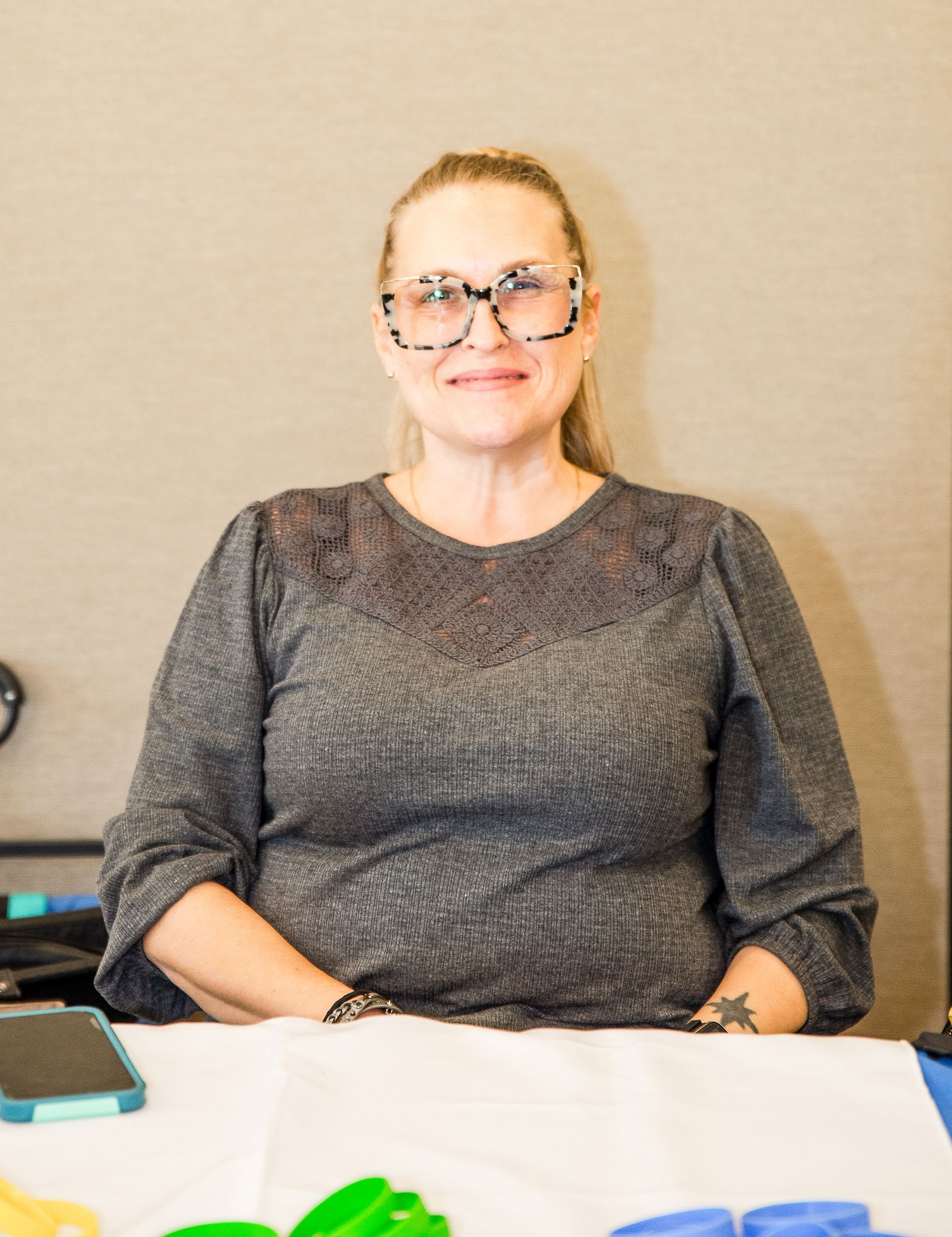A woman wearing glasses is sitting at a table.