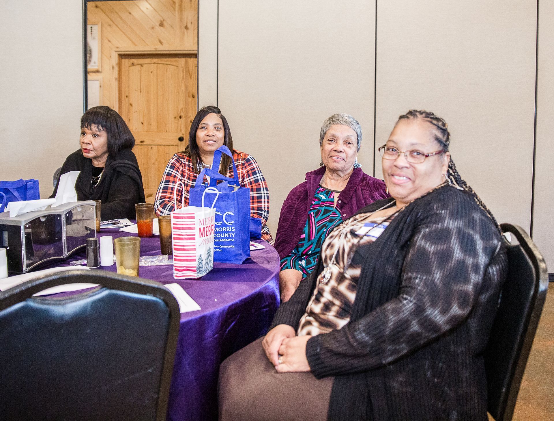 A group of women are sitting at a table in a room.