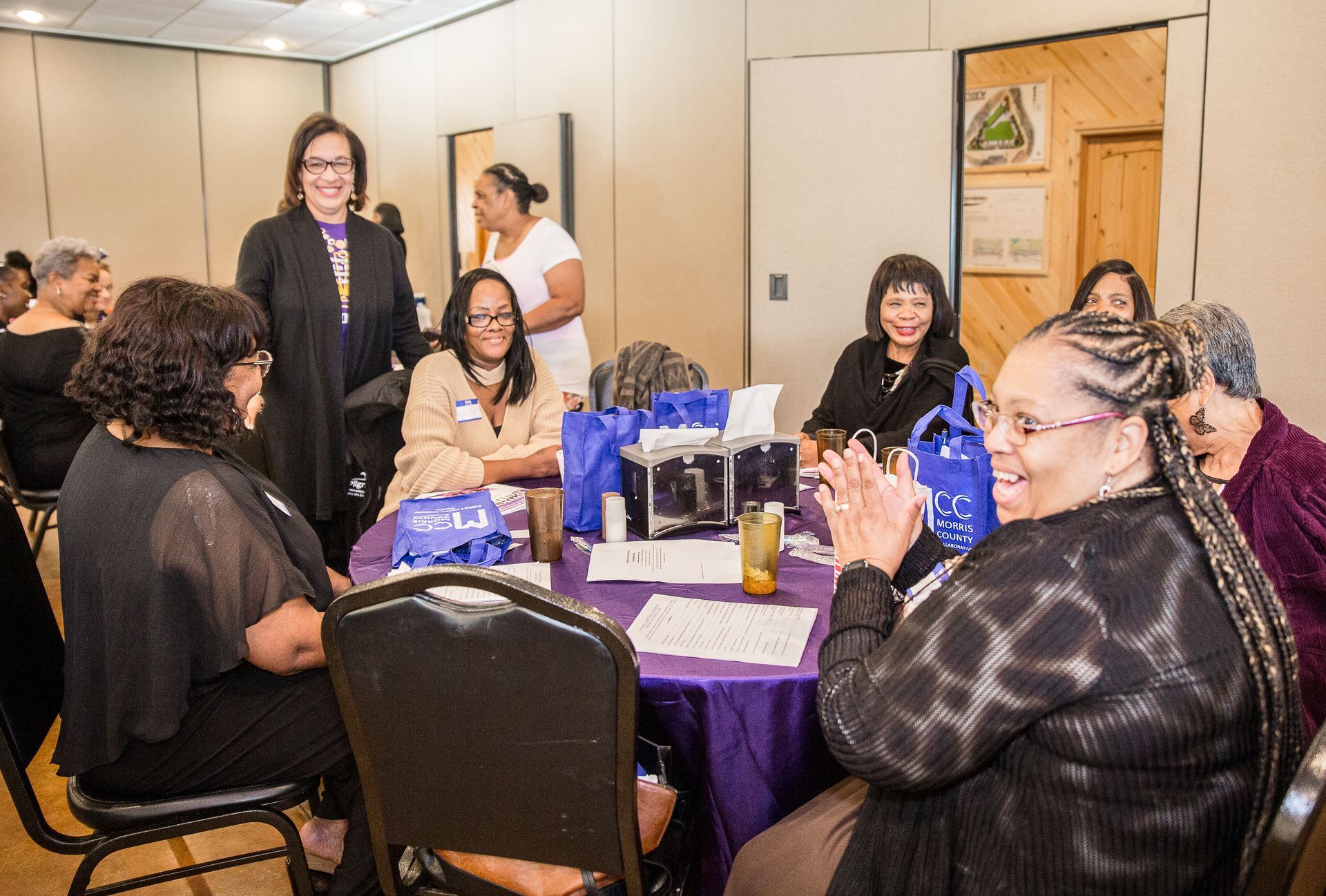 A group of women are sitting around a table in a room.