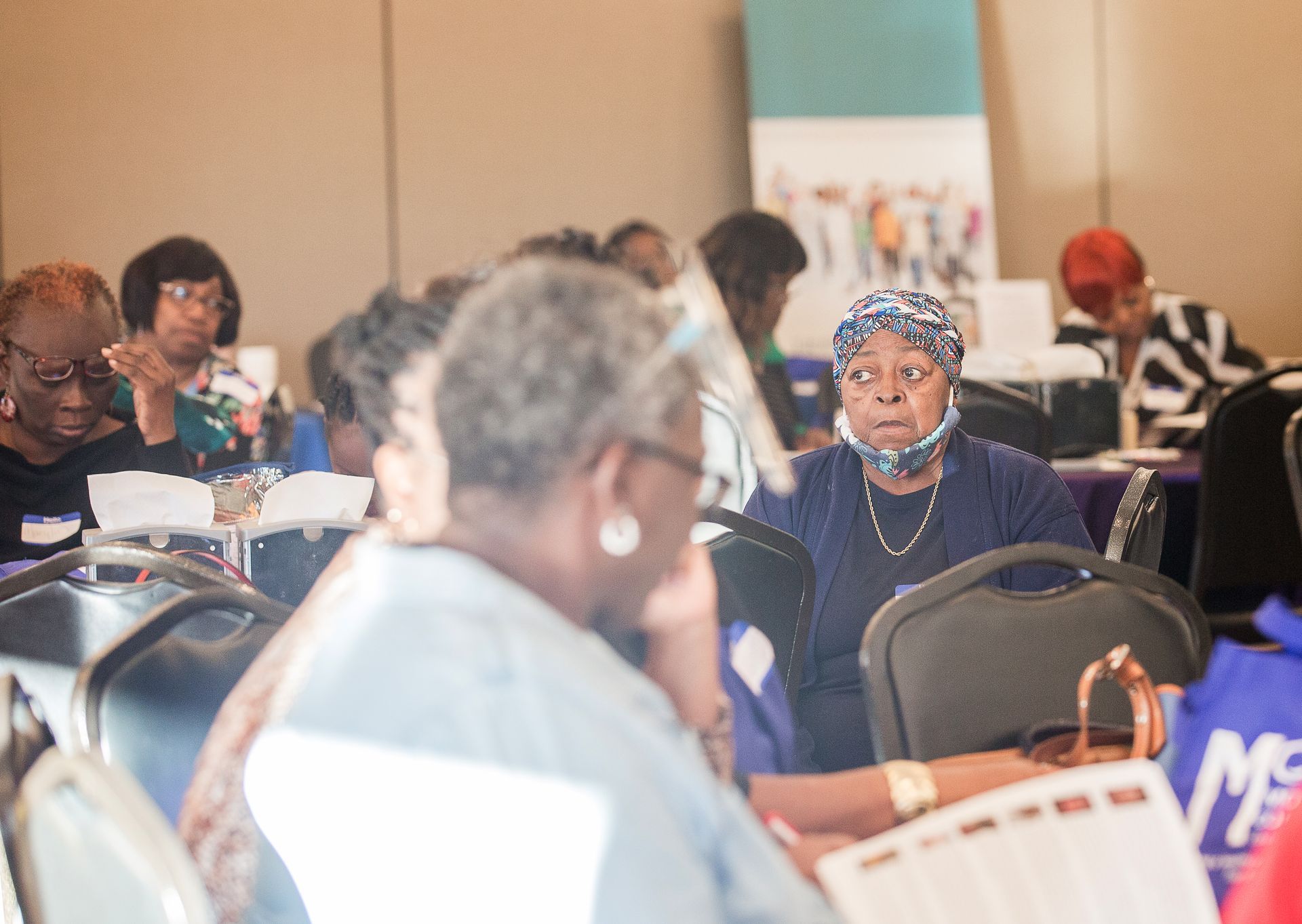 A group of people are sitting at tables in a room.
