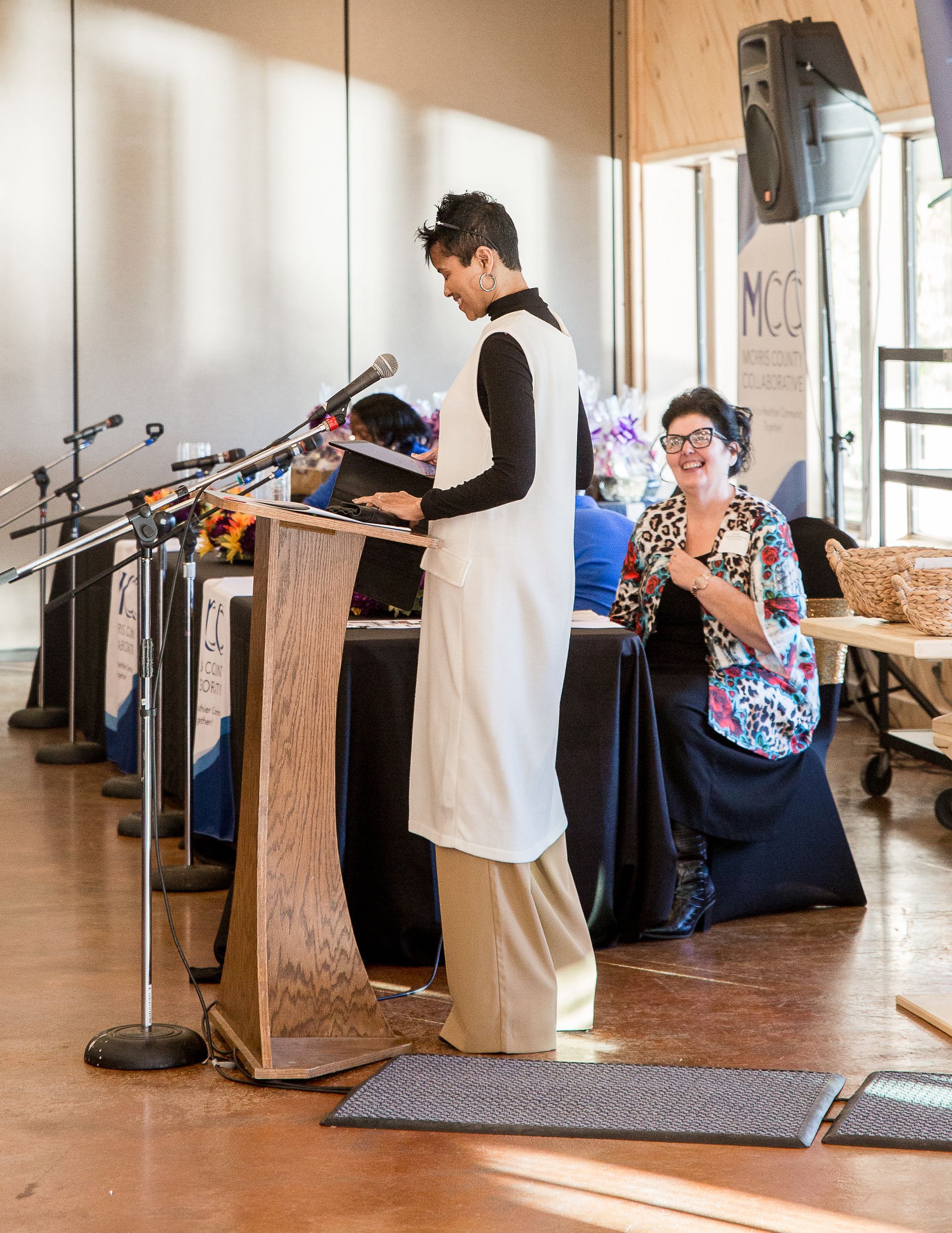 A woman is standing at a podium talking into a microphone.