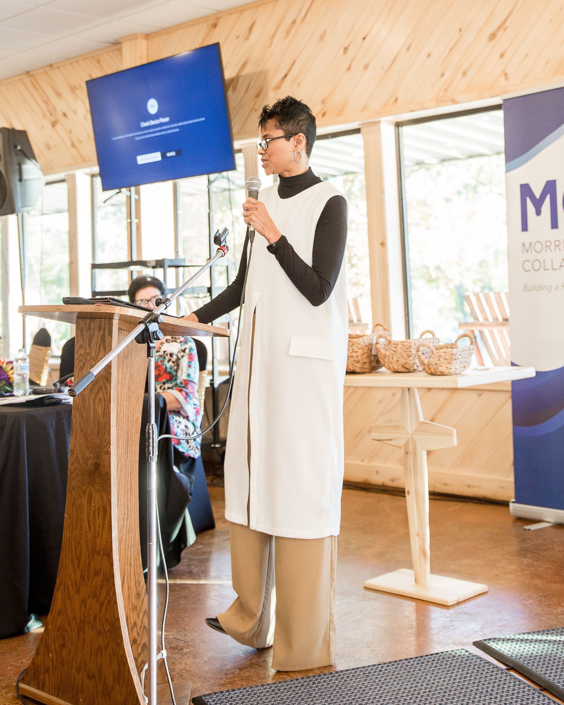 A woman is standing at a podium holding a microphone