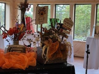 A table with a vase of flowers and a sign that says honey