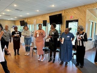 A group of women are standing in a circle in a room.
