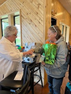 A woman is giving flowers to another woman in a restaurant.