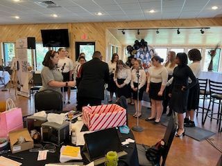 A group of people are standing around a microphone in a room.