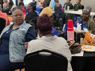 A group of people are sitting at tables in a room.
