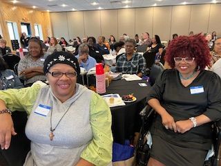 A group of women are sitting at tables in a room.