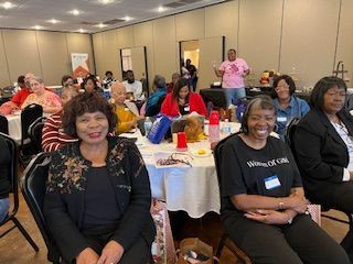 A group of women are sitting at tables in a room.