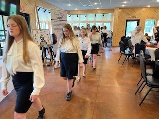 A group of young women are walking down a hallway.