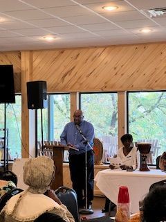 A man is standing at a podium giving a speech to a group of people.