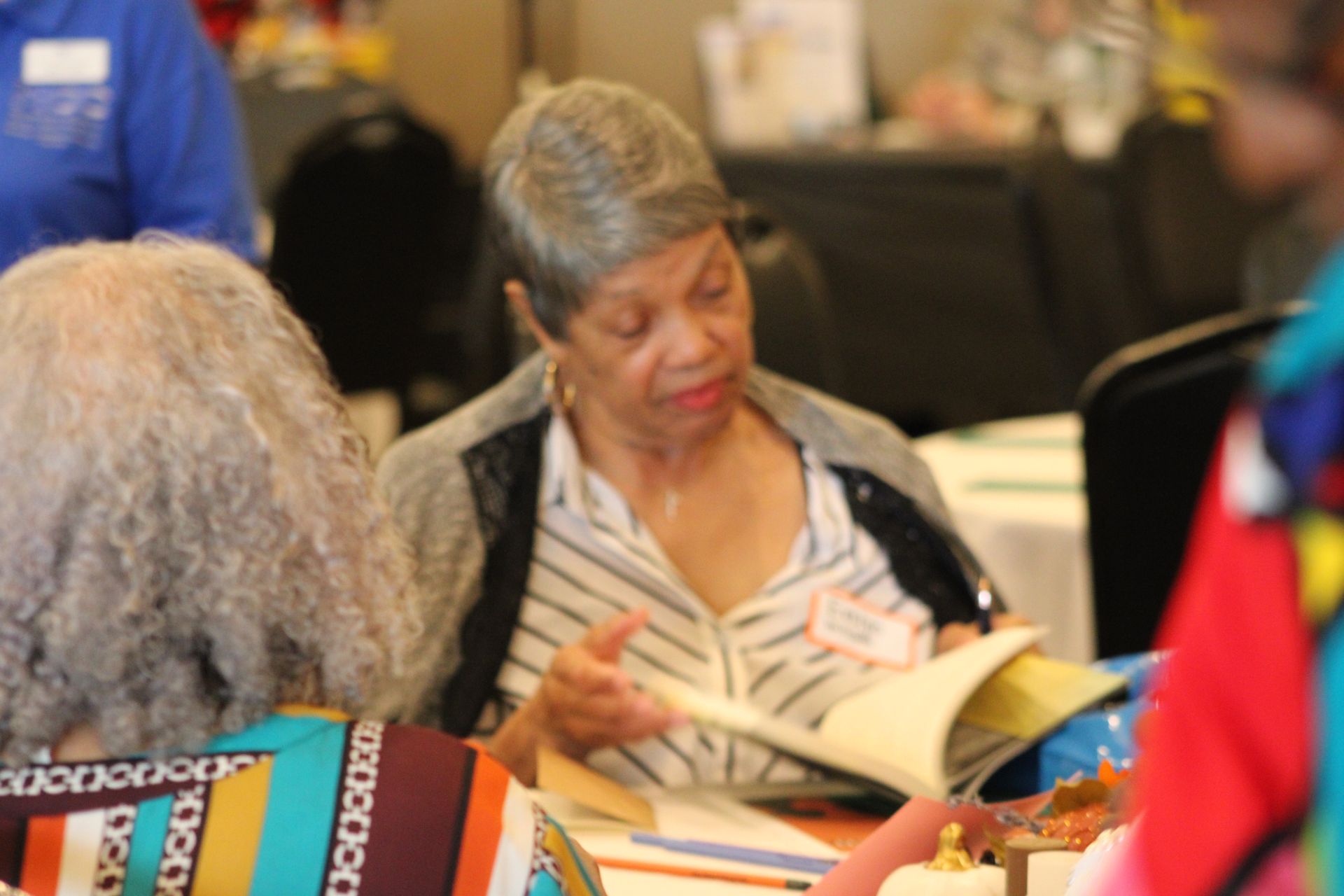 A woman is sitting at a table reading a book