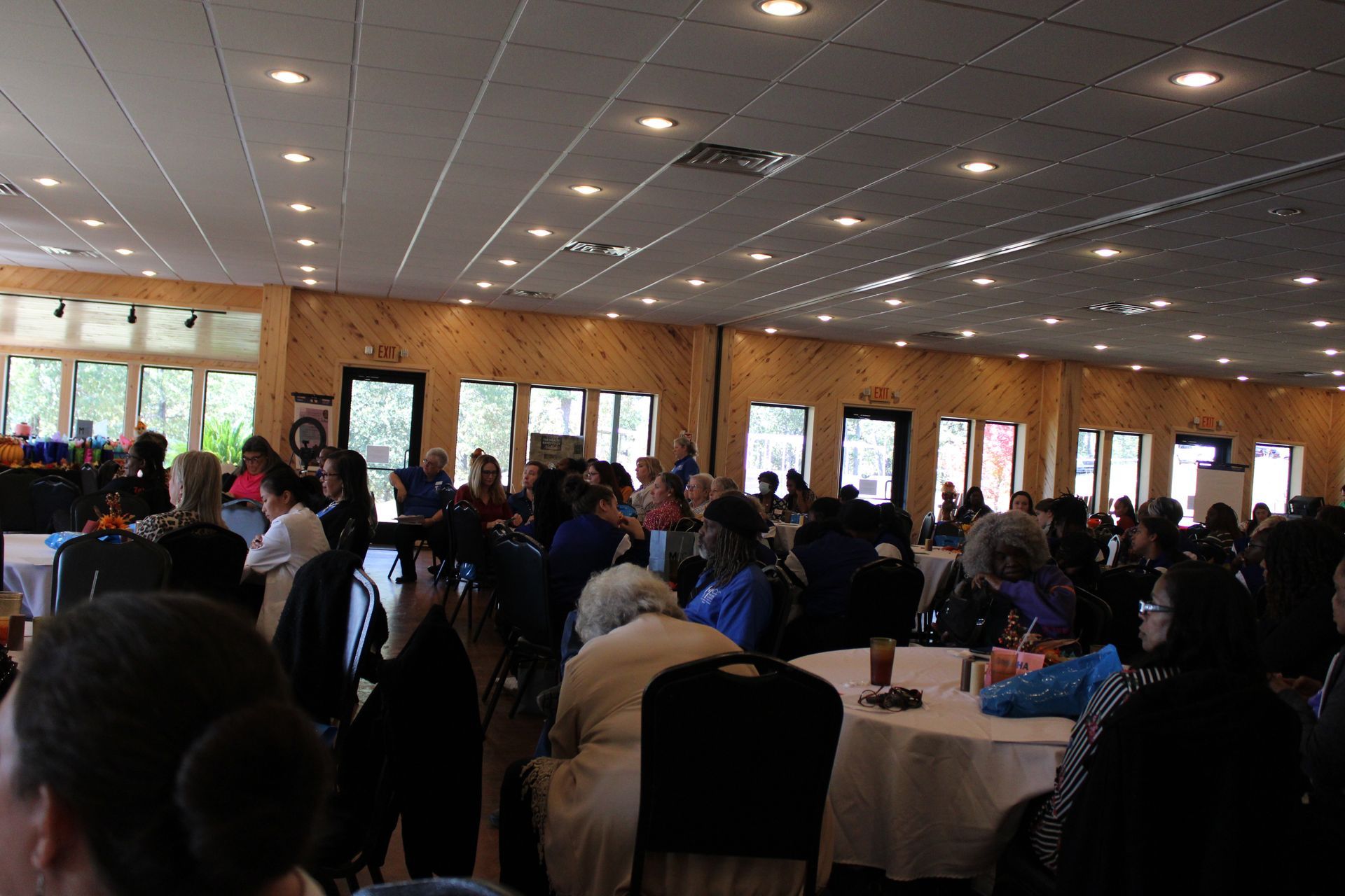 A large group of people are sitting at tables in a large room.