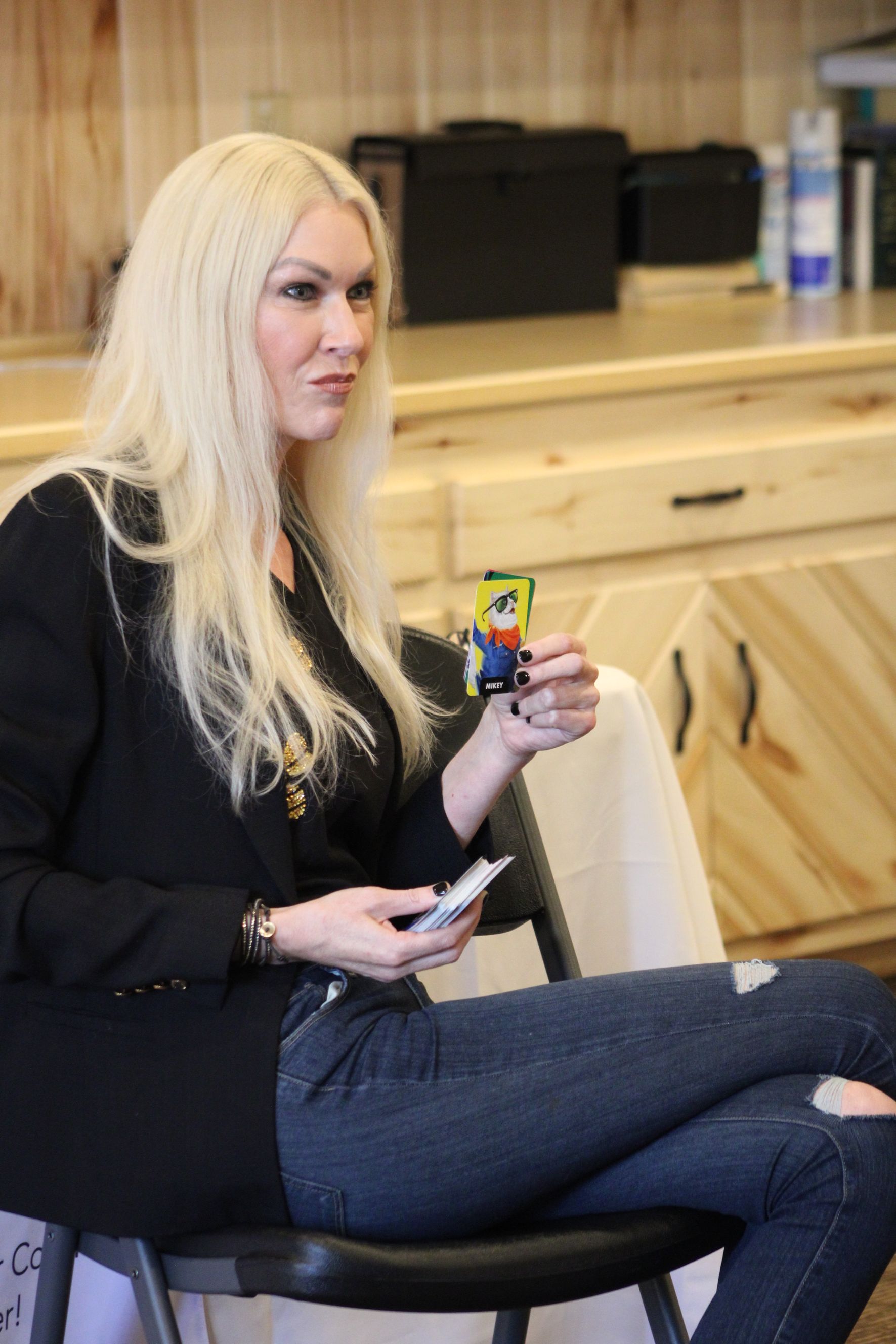 A woman is sitting in a chair holding a rubik 's cube.