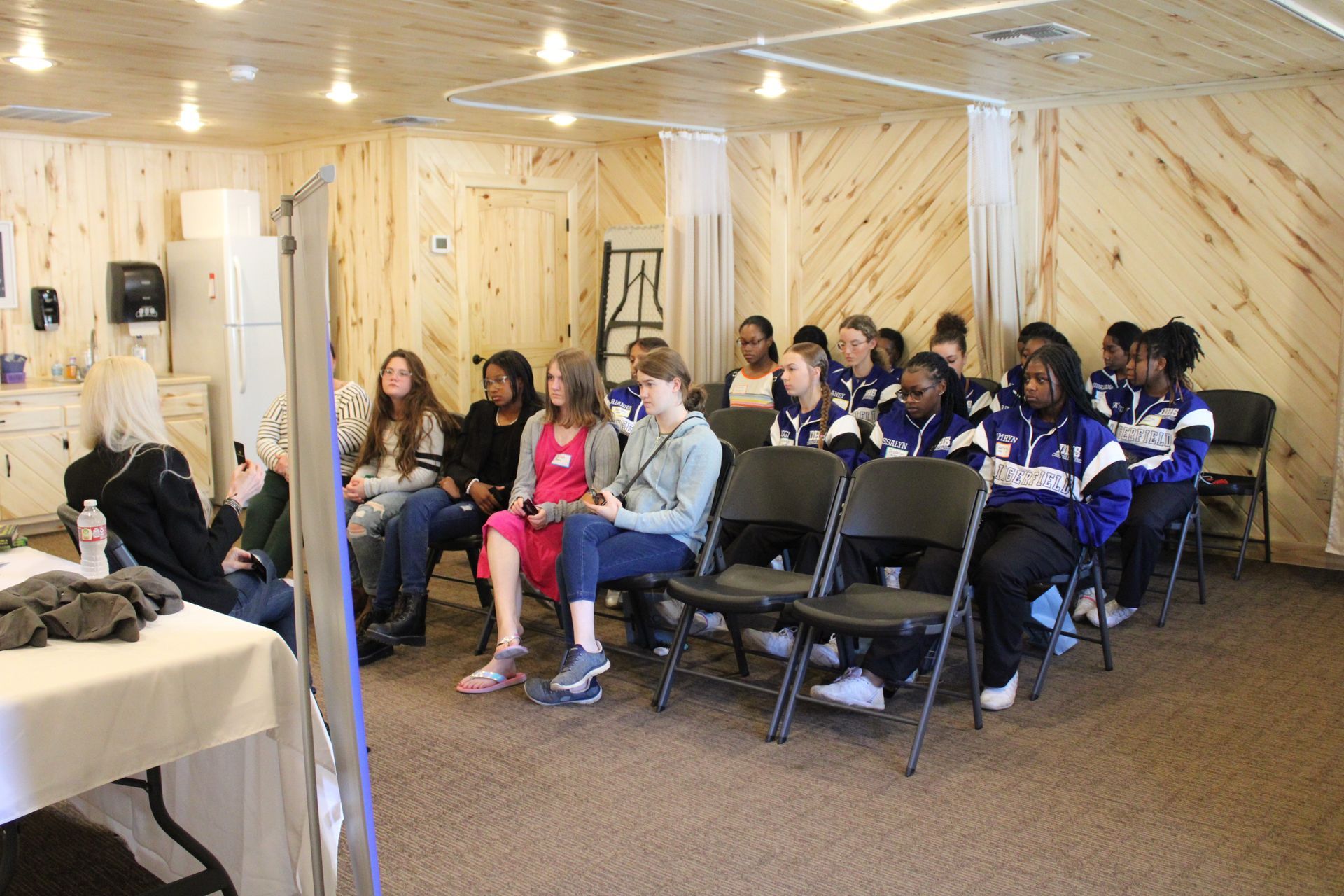 A group of people are sitting in chairs in a room.