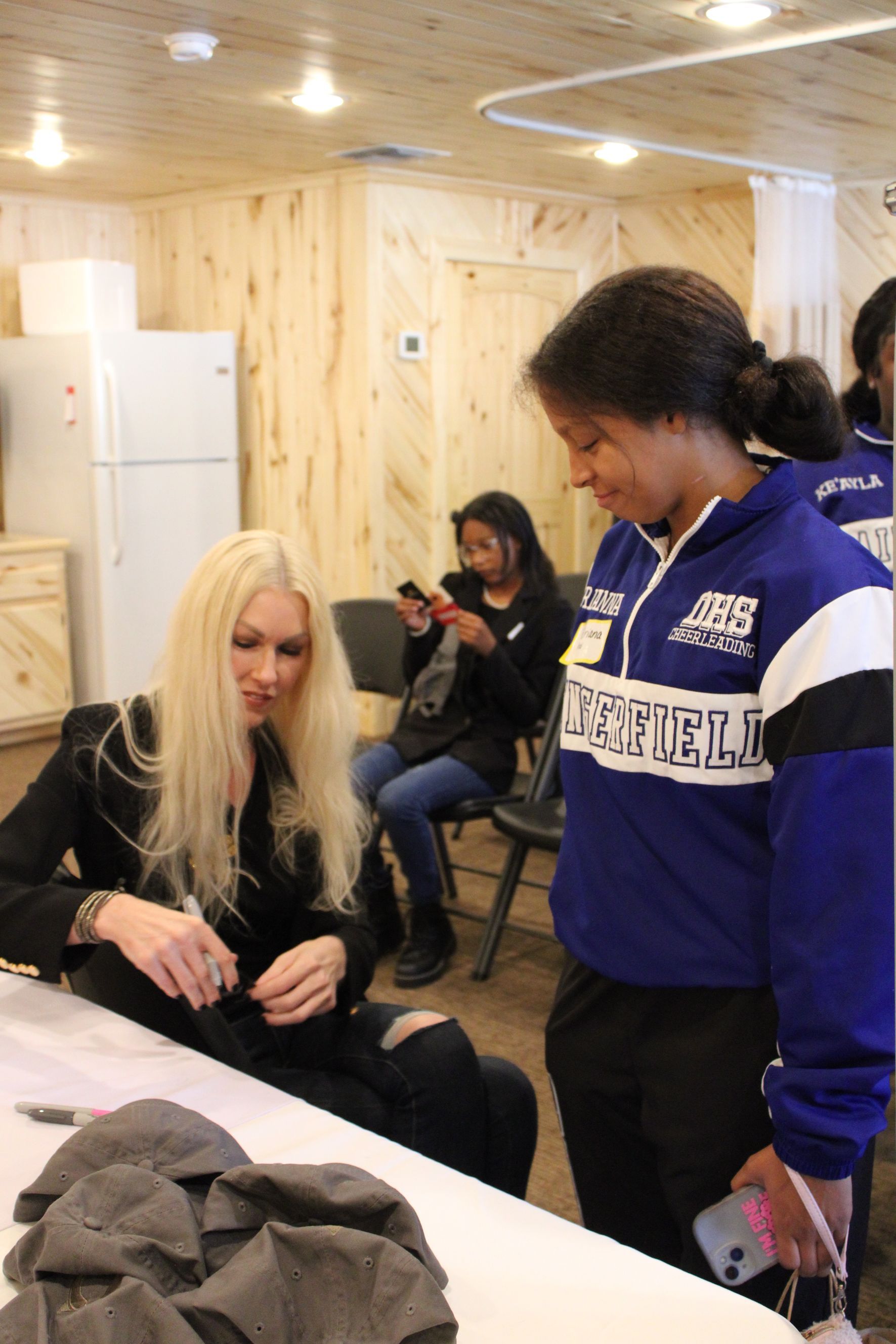 A woman in a blue sweatshirt with the word shield on it