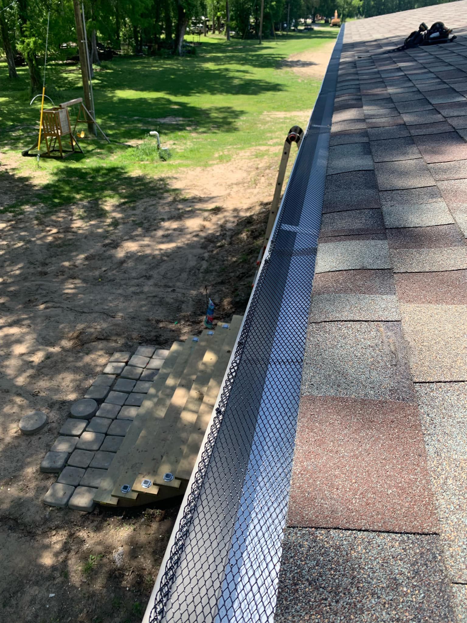A gutter is being installed on the side of a roof.