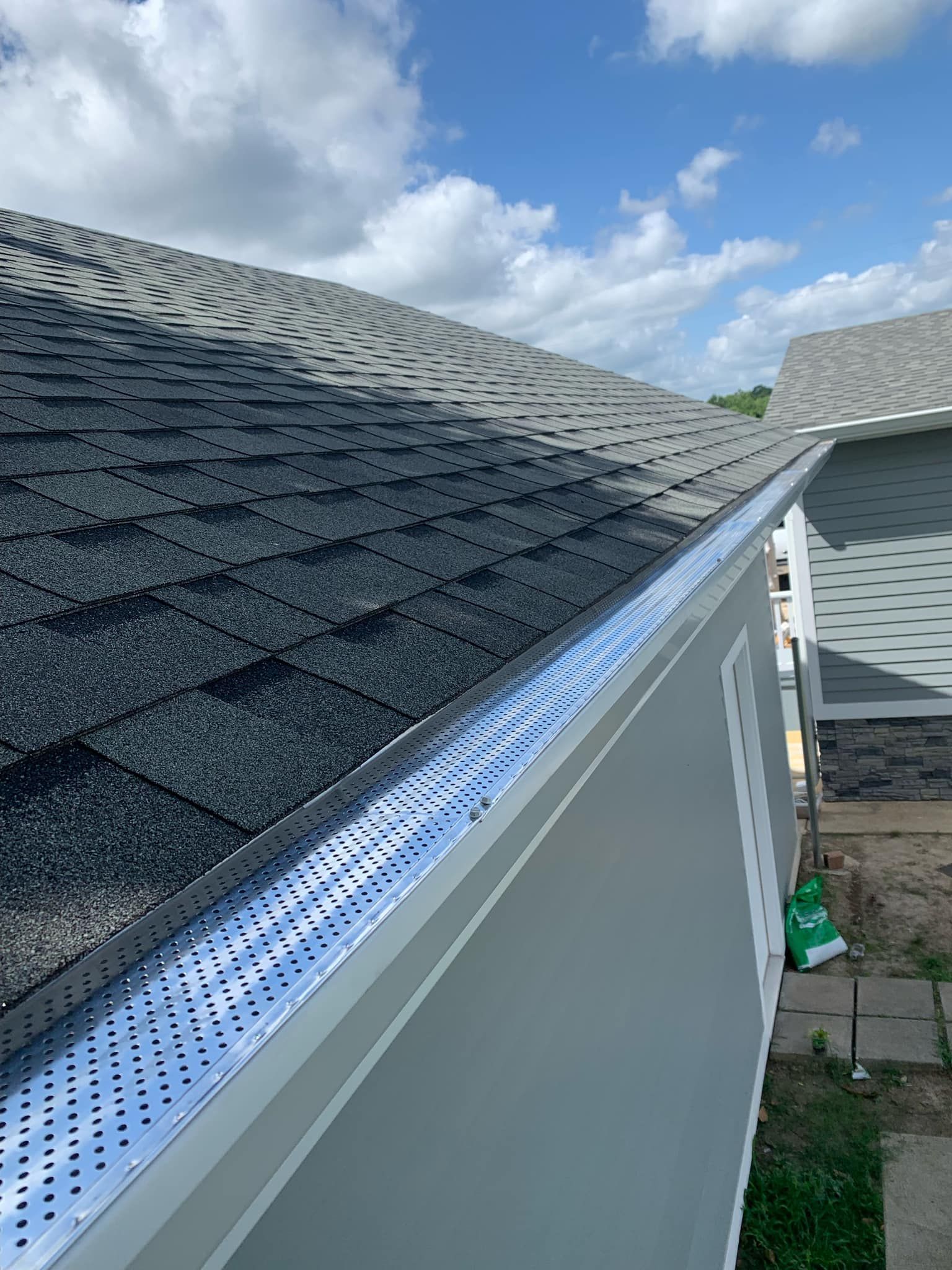 A close up of a gutter on the side of a house.