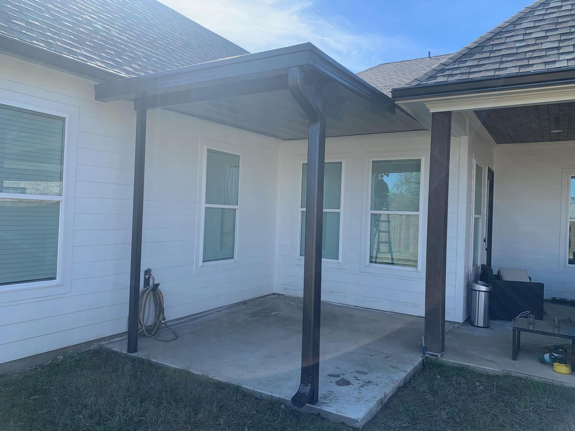 A white house with a porch and a lot of windows.