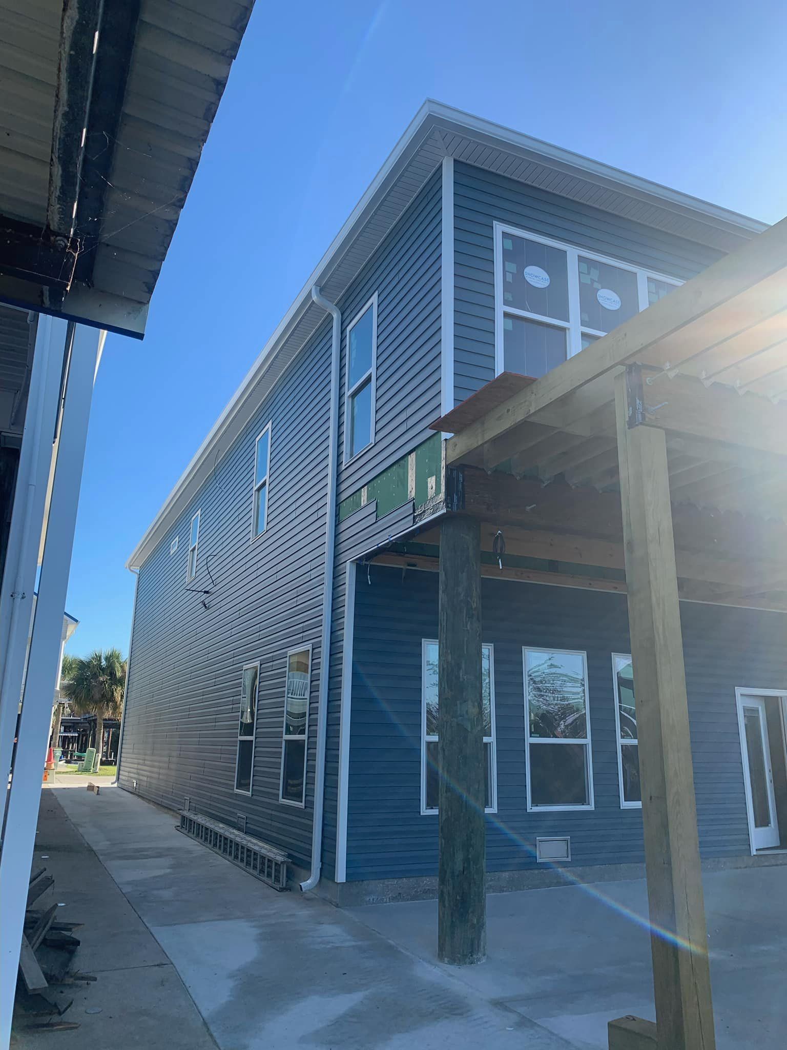 A large blue building with a lot of windows and a wooden porch.