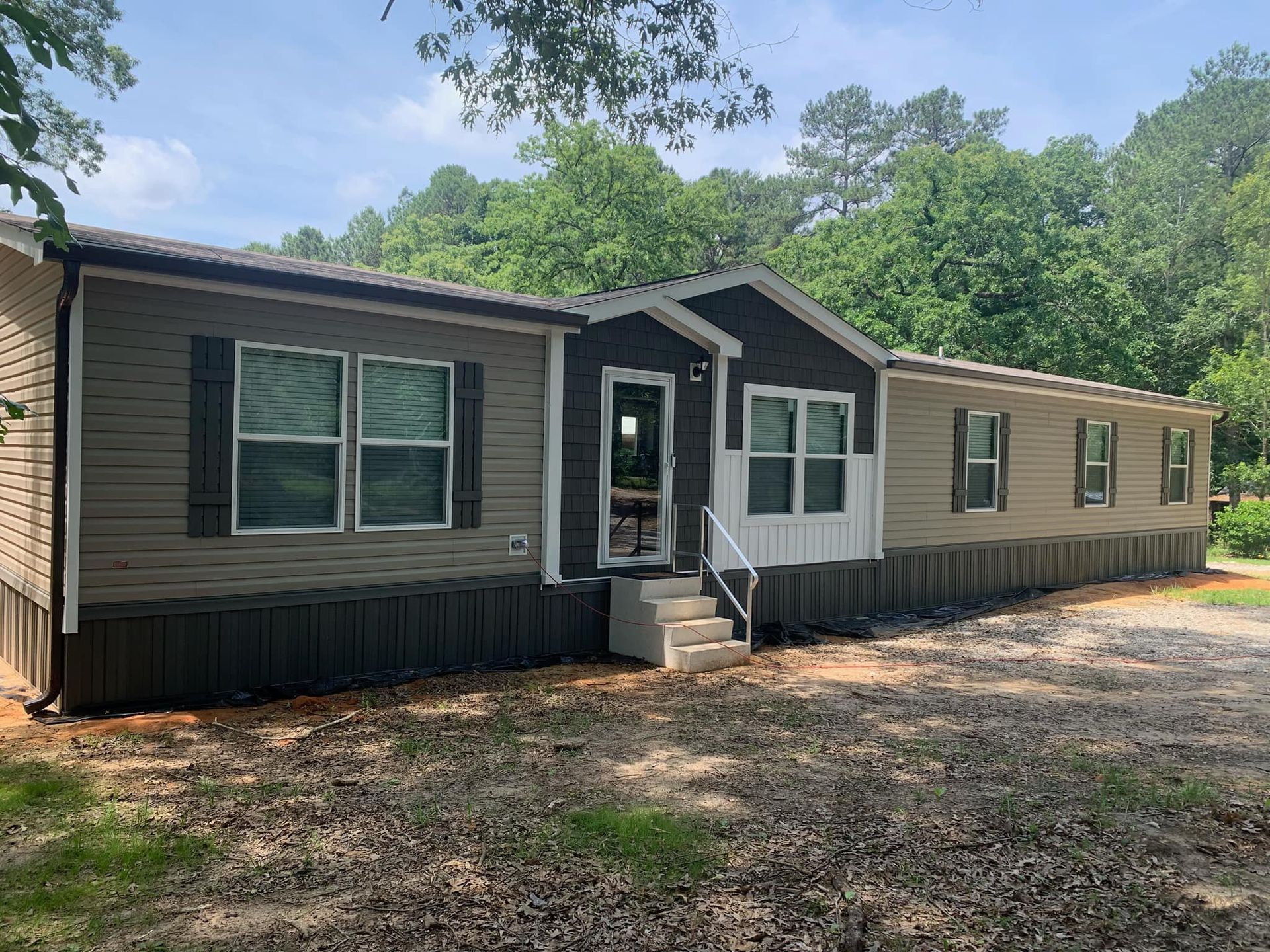 A large mobile home with a lot of windows and stairs in front of it.