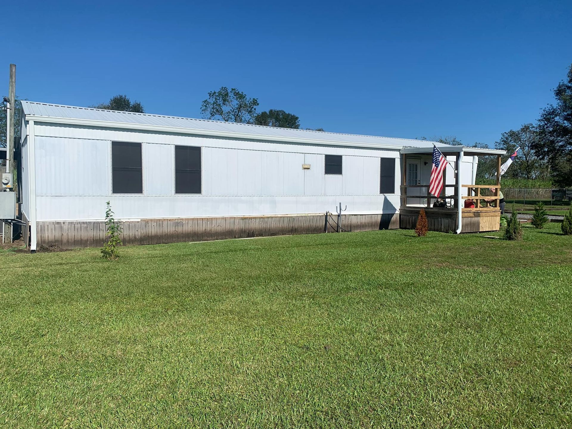 A mobile home is sitting in the middle of a grassy field.