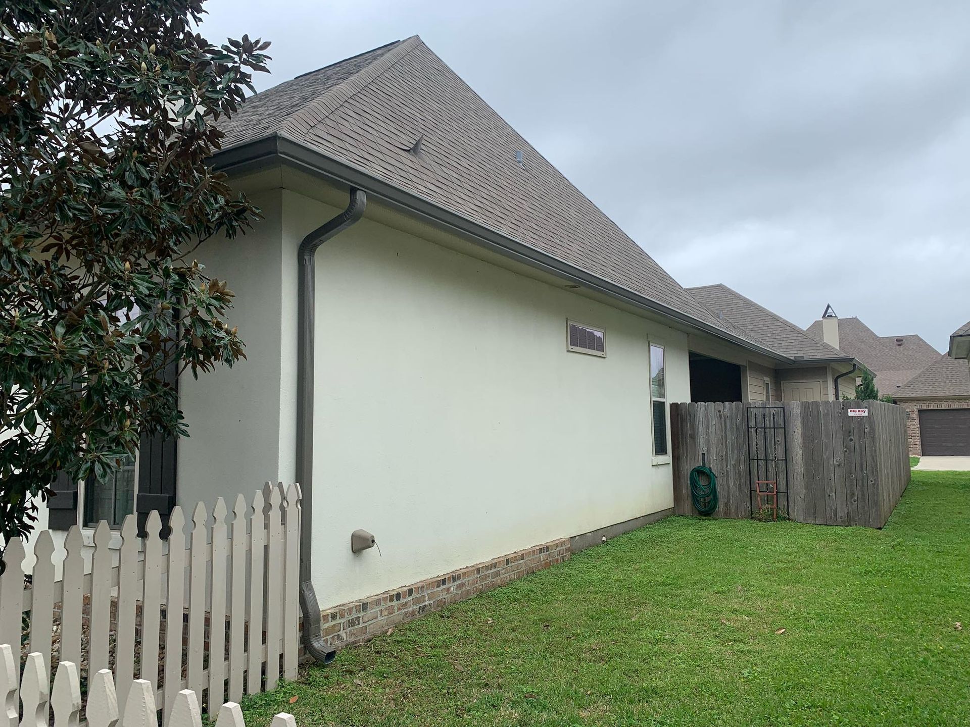 A white house with a white picket fence in front of it.