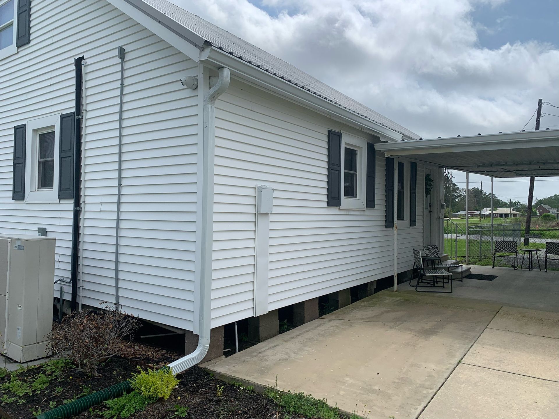 A white house with a carport on the side of it.
