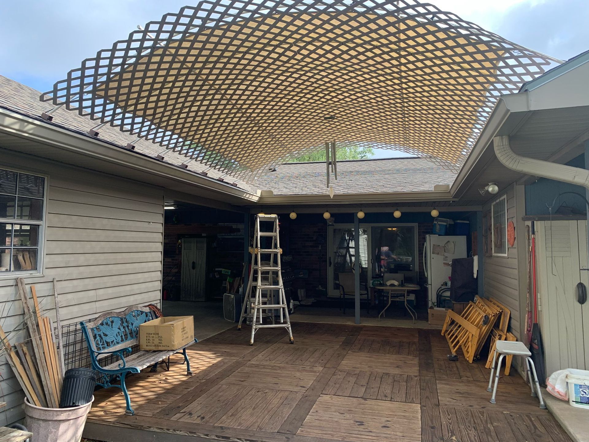 A wooden pergola is being built in the backyard of a house.