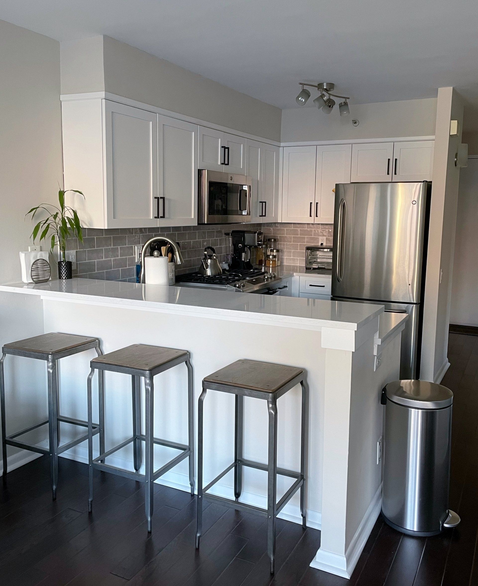 A kitchen with white cabinets and stainless steel appliances