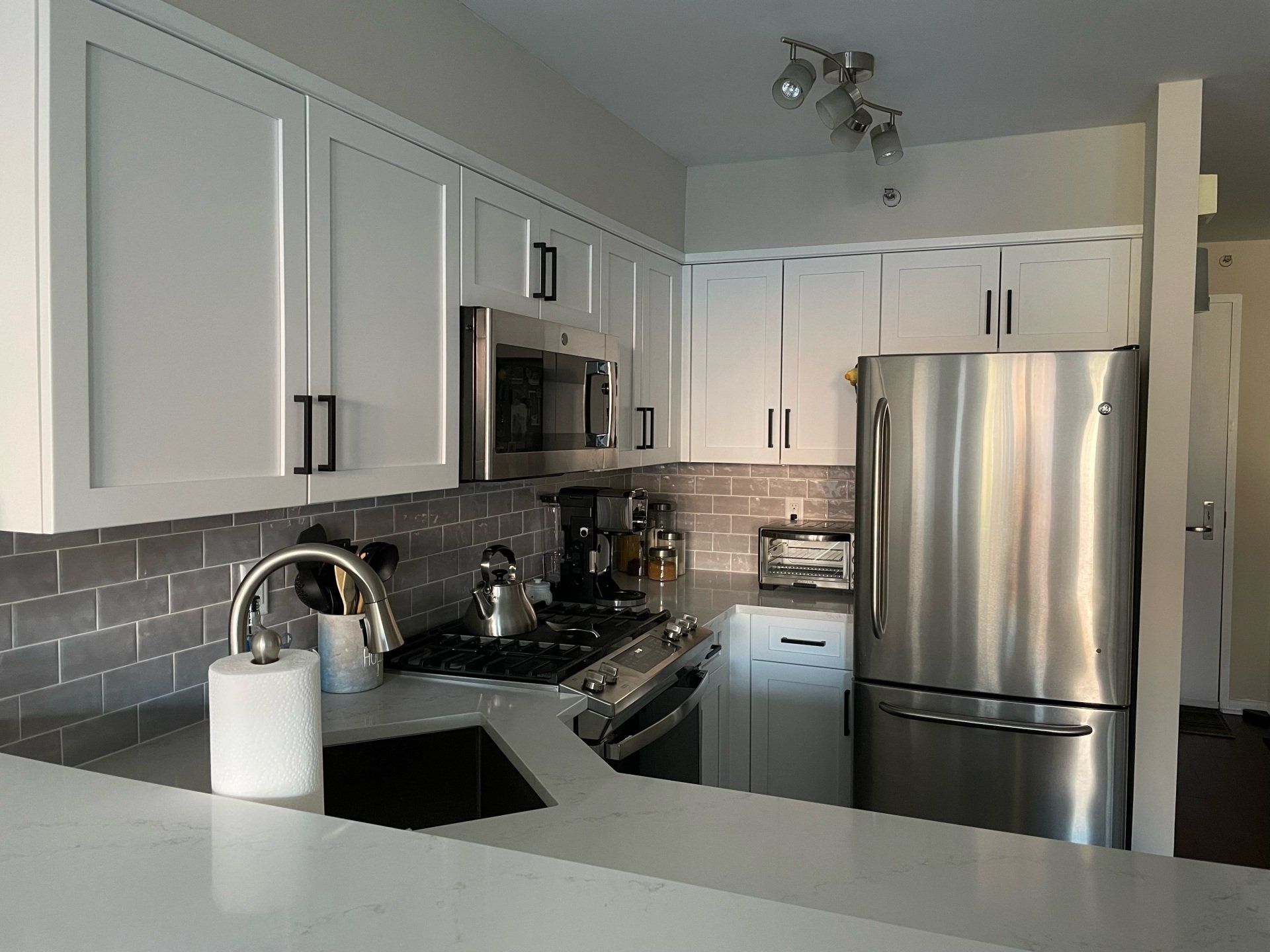 A kitchen with stainless steel appliances and white cabinets